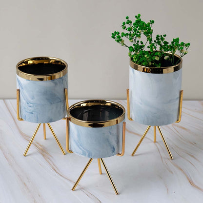 A stylish marble finish planter with gold metal stand styled on a clean lifestyle backdrop creating a modern accent for home decor.