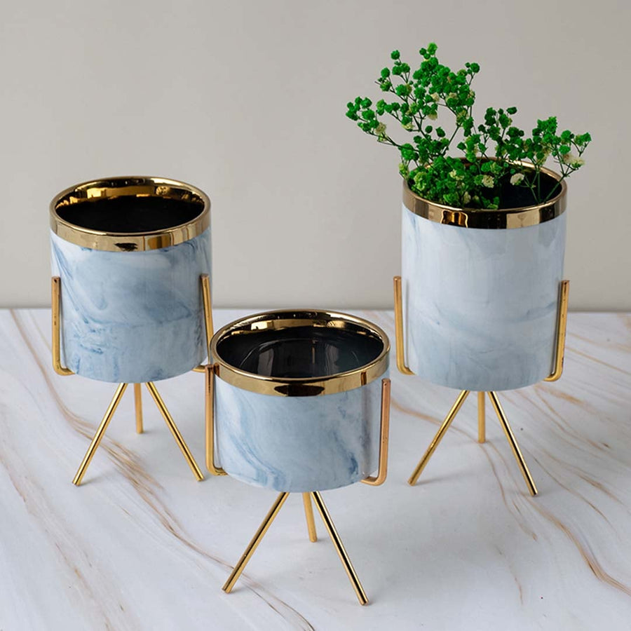 A stylish marble finish planter with gold metal stand styled on a clean lifestyle backdrop creating a modern accent for home decor.