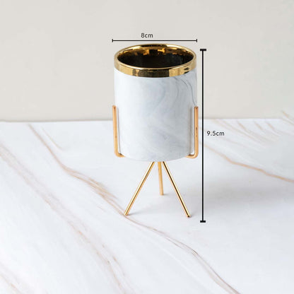 A marble finish planter with gold stand shown with measurements of 8 cm width and 9.5 cm height clearly illustrating its compact size.
