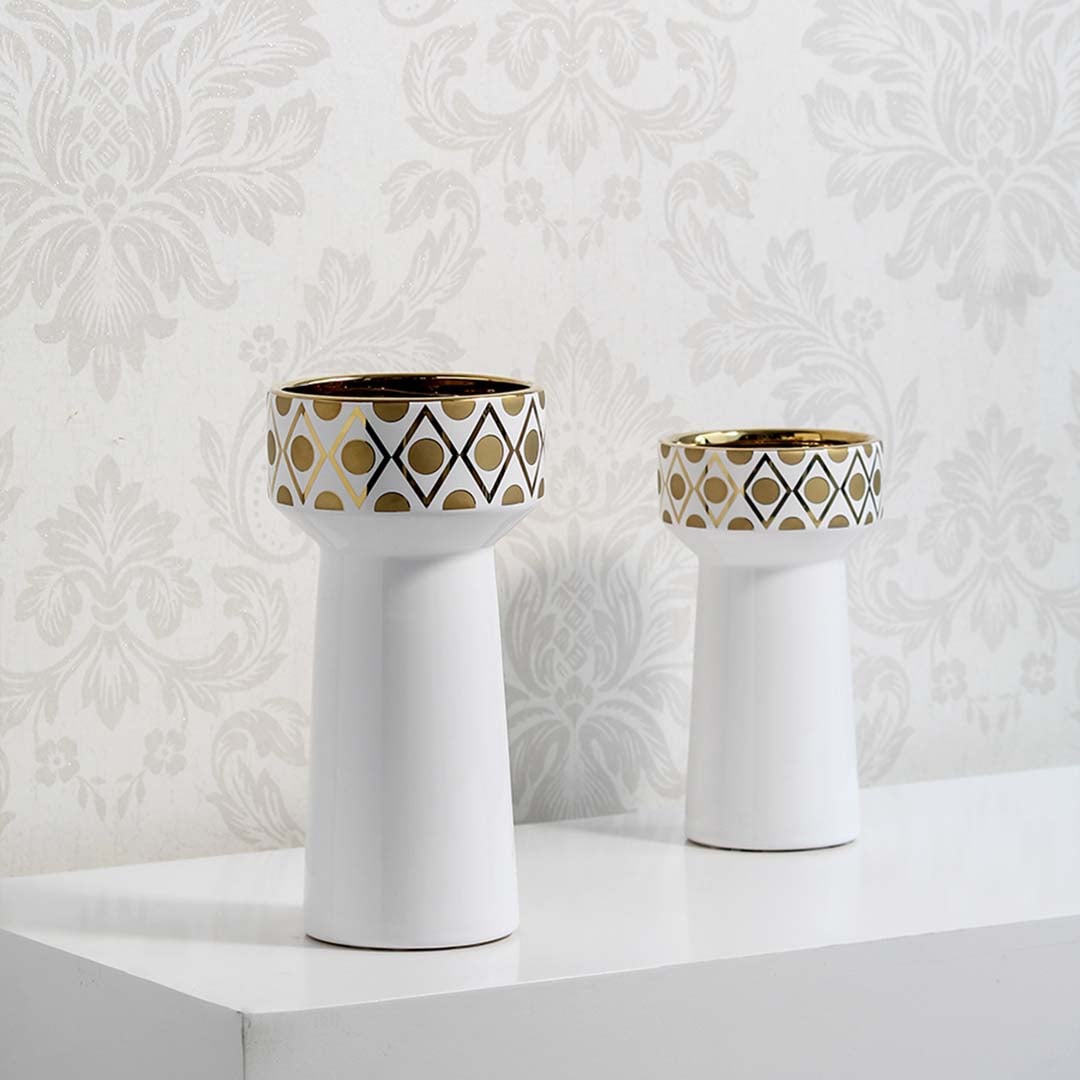 Collection of white ceramic vases with gold geometric patterns grouped on white background displaying modern decor set style.