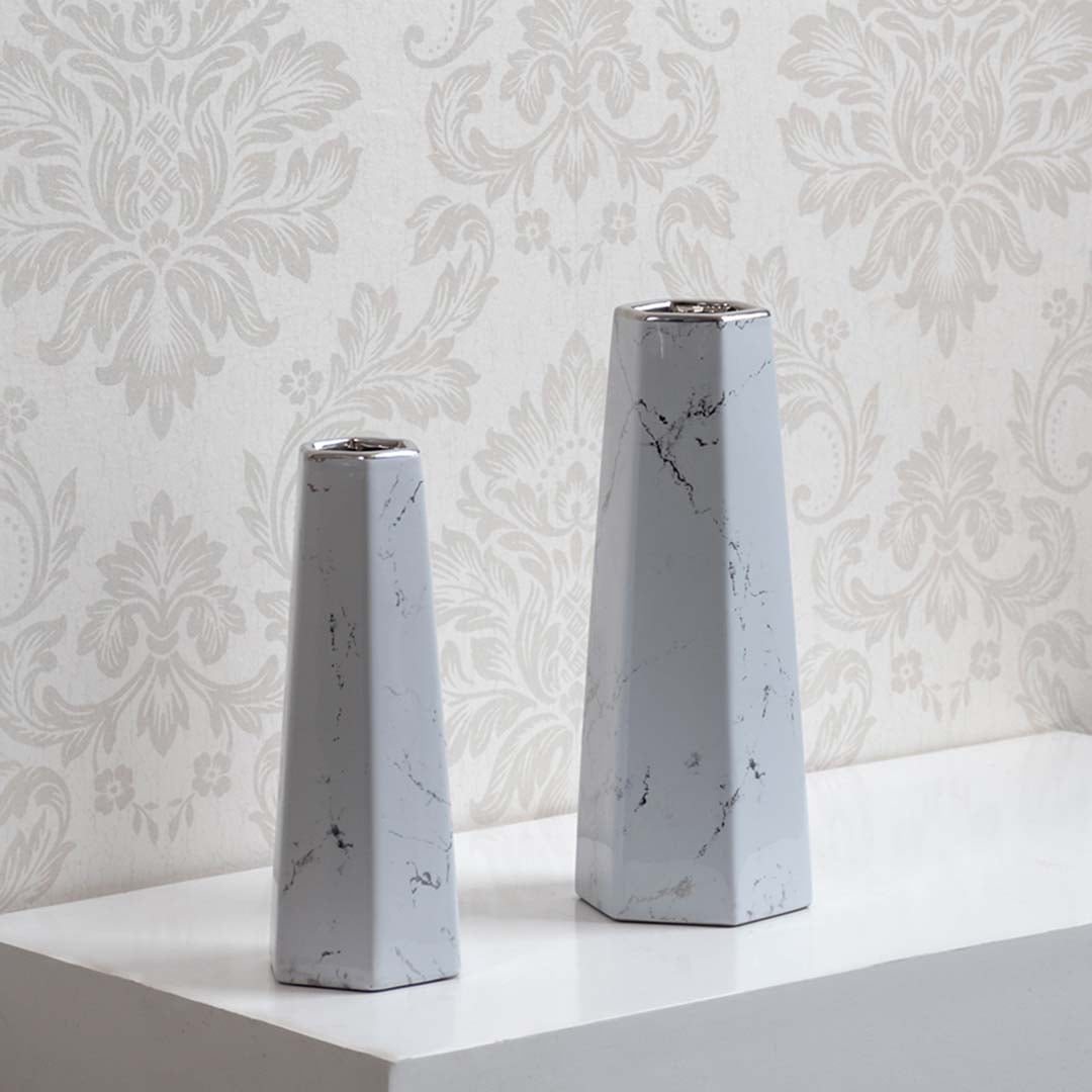 Collection of modern white marble ceramic vases with geometric design ideal for tabletop decor and flower display.