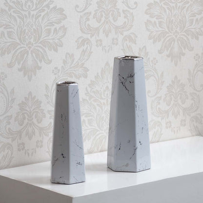 Collection of modern white marble ceramic vases with geometric design ideal for tabletop decor and flower display.