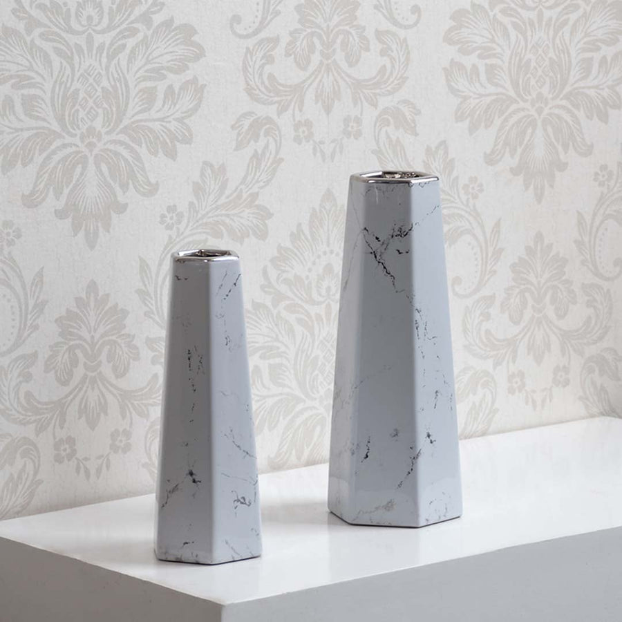 Collection of modern white marble ceramic vases with geometric design ideal for tabletop decor and flower display.