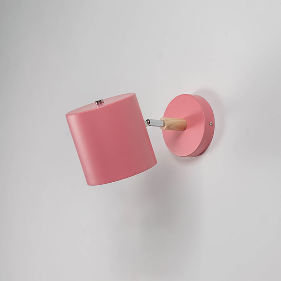 Muted pink wall lamp with wooden arm off against white wall highlighting its minimal modern appeal.
