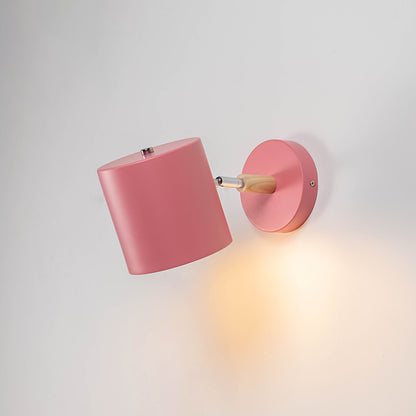 Pink metal wall light with warm glow for stylish bedroom nursery and modern home decor spaces.

