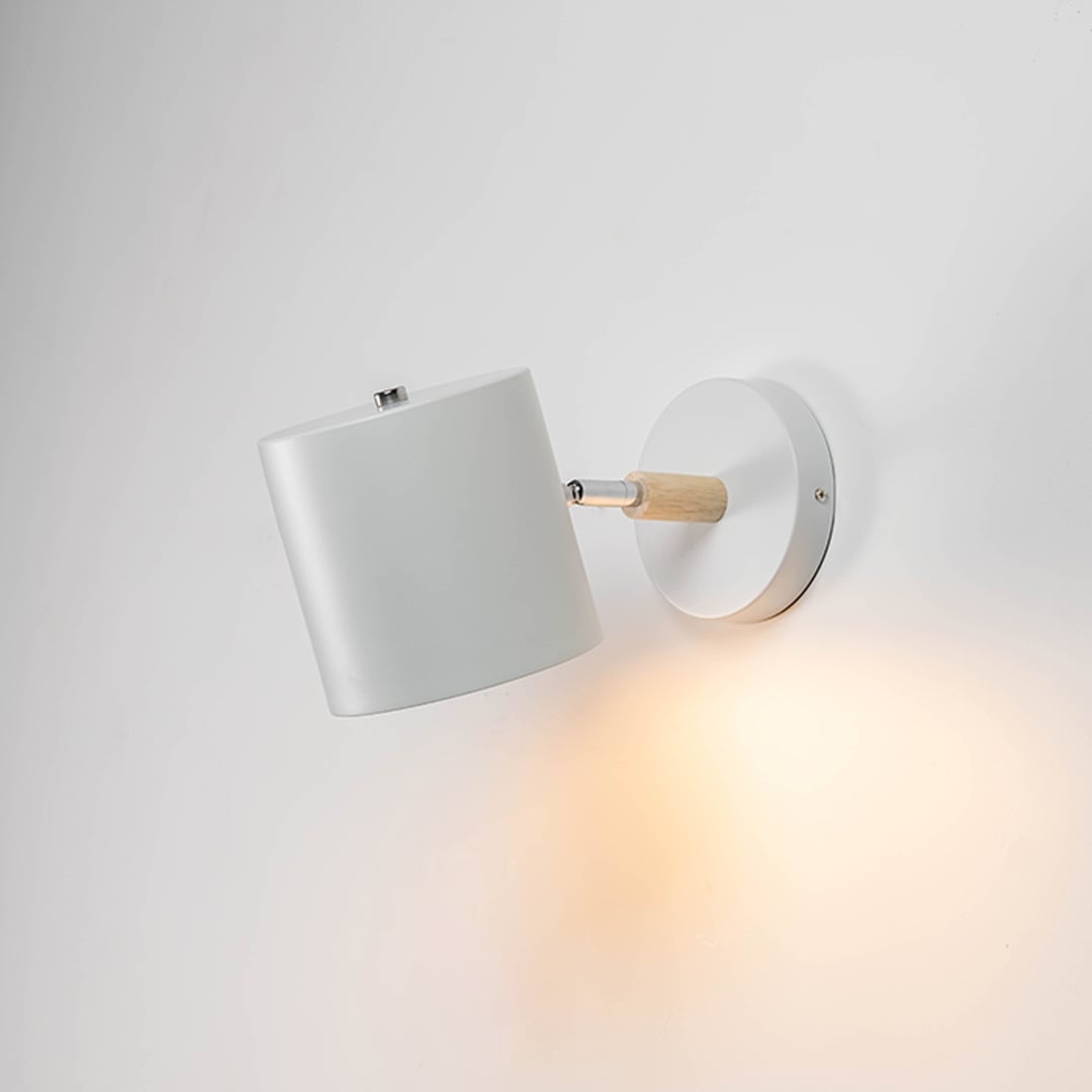 A modern lantern shown on a white background with the inner candle light on creating a warm glow that highlights the clear glass panels and smooth matte finish of the frame.
