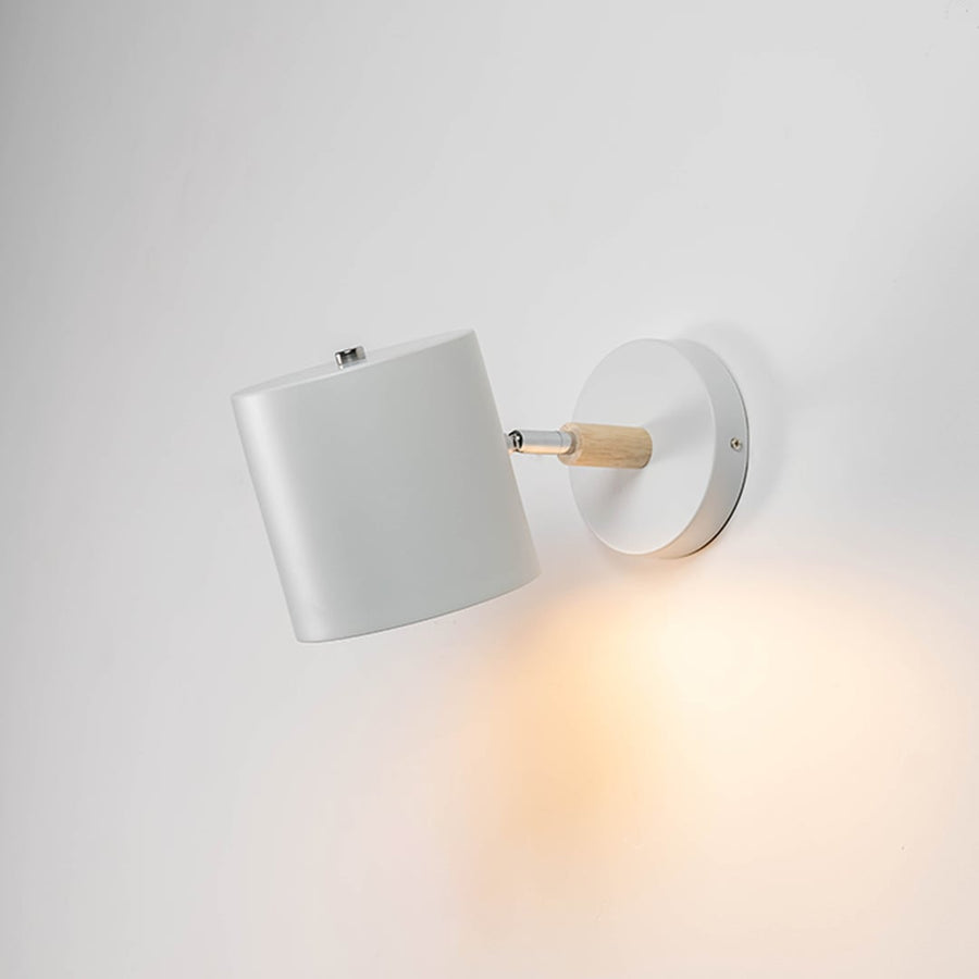 A modern lantern shown on a white background with the inner candle light on creating a warm glow that highlights the clear glass panels and smooth matte finish of the frame.