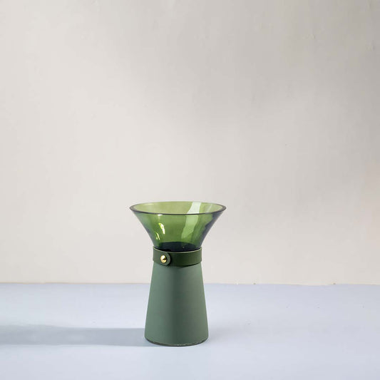 Green glass decorative vase with flared geometric silhouette for shelf styling and contemporary home decor displays.