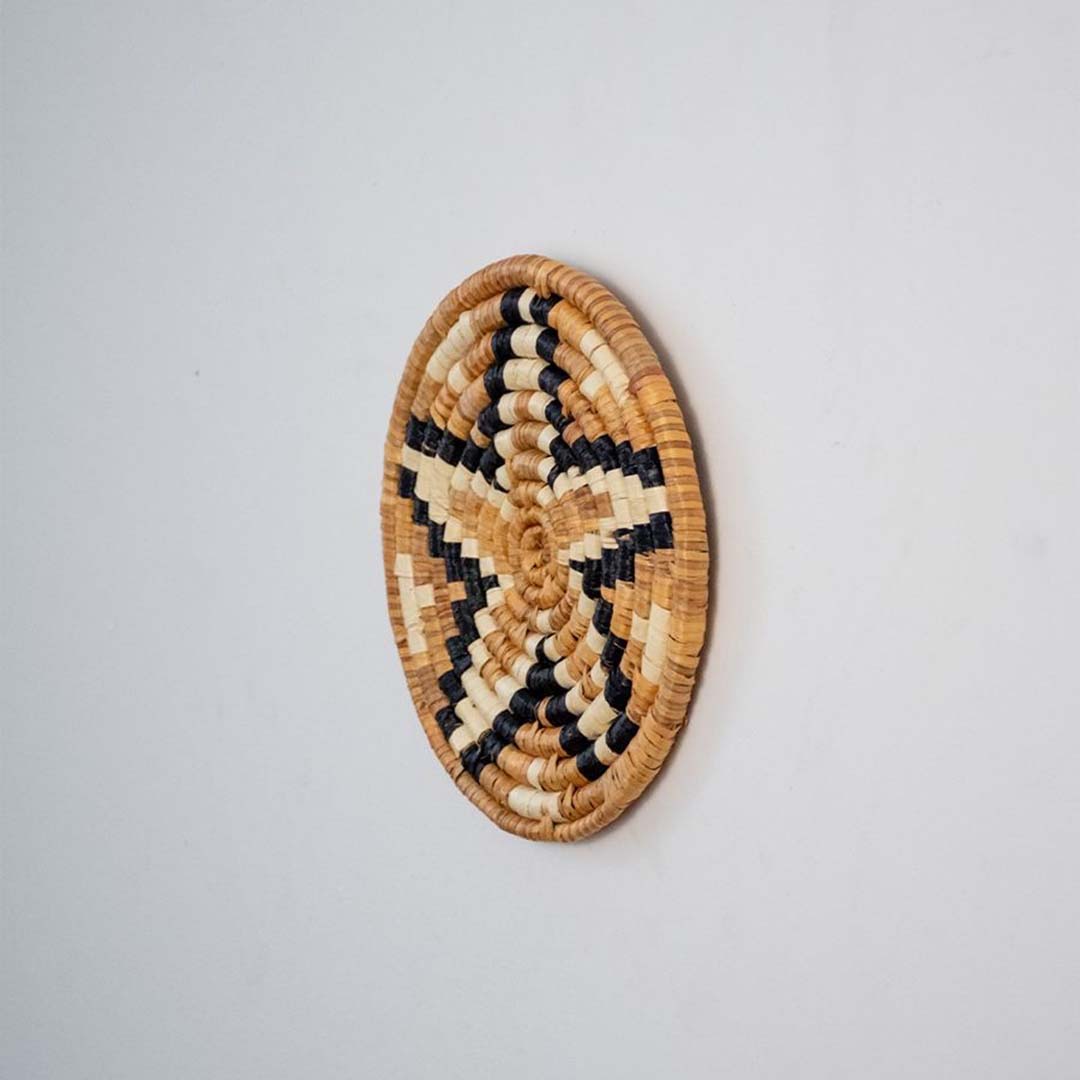 Side profile of bamboo wall plate in black beige brown hues highlighting natural weave and handcrafted finish.