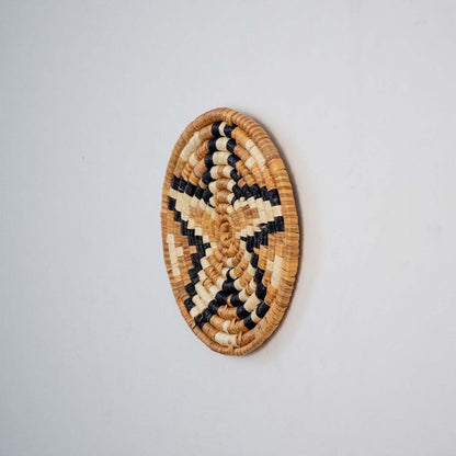 Side profile of bamboo wall plate in black beige brown hues highlighting natural weave and handcrafted finish.