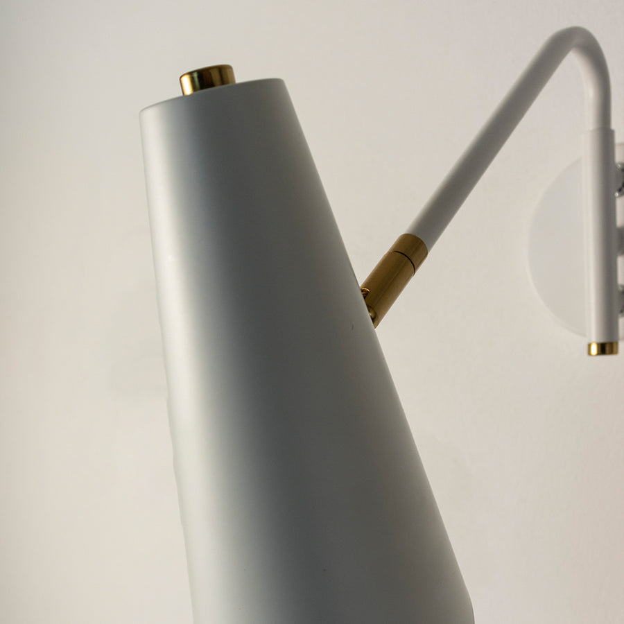 Closeup of grey metal wall light with gold accents for modern bedroom and contemporary hallway decor spaces.