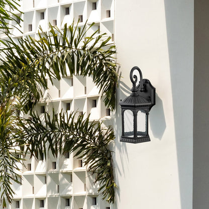 Outdoor wall sconce enhancing home exterior mounted on stone wall near wooden entrance door adding vintage charm.