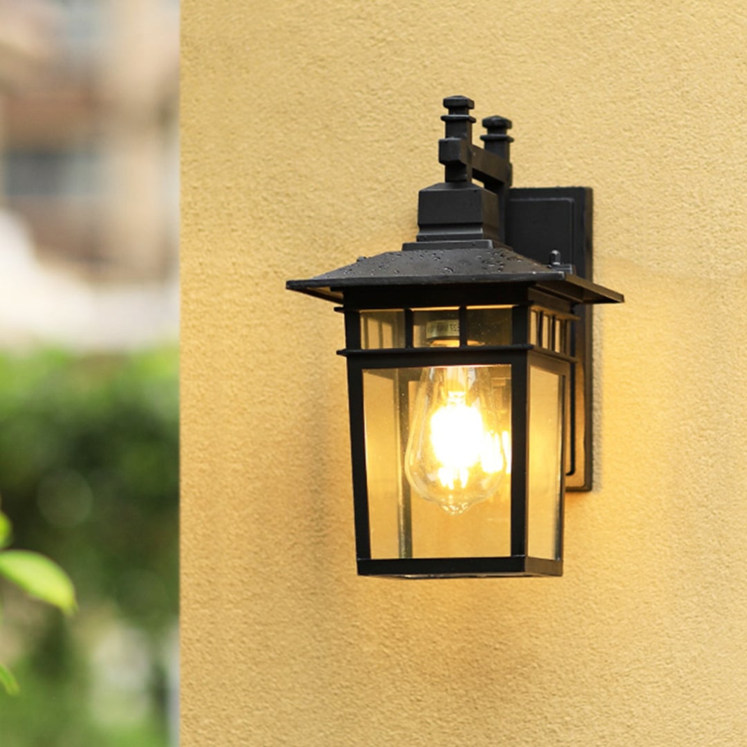 Outdoor wall lantern light illuminating entrance with elegant black frame design for modern exterior decor.
