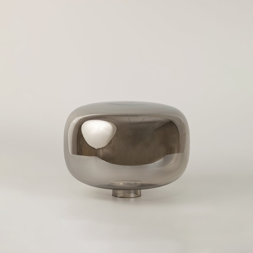 Halo glass table lamp with golden base and dome shade displayed on white background with light turned on for interiors.
