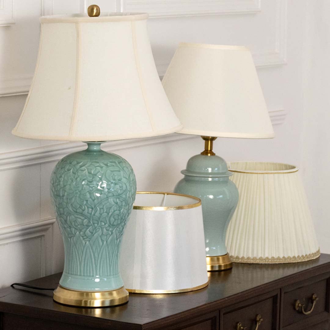Elegant two blue ceramic table lamps with gold metal base and white fabric shade adds a soft refined touch to home decor.