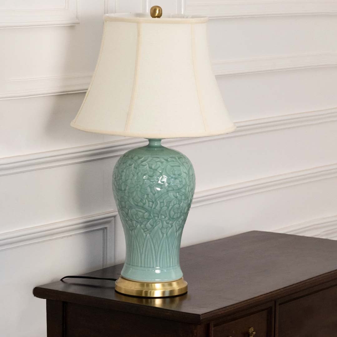 Unlit blue ceramic lamp with gold base and white shade showcases its refined silhouette and exquisite craftsmanship adding artistic charm.