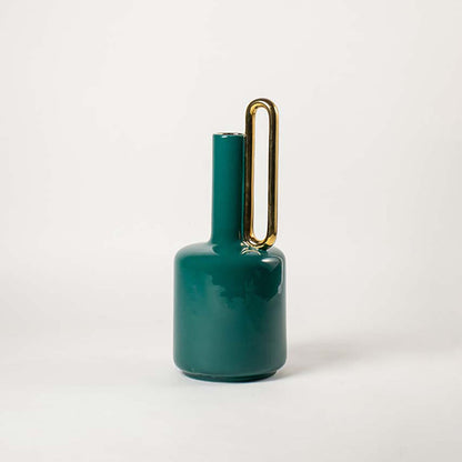 Modern glossy emerald green ceramic jug vase with single high gold handle on white background for rich contemporary styling.