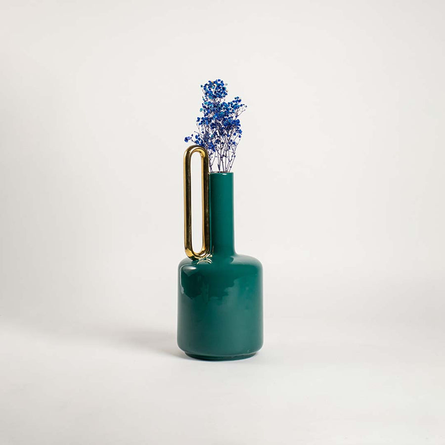 Tall teal ceramic vase with a gold handle placed in a bright interior perfect for living rooms consoles and refined home styling.