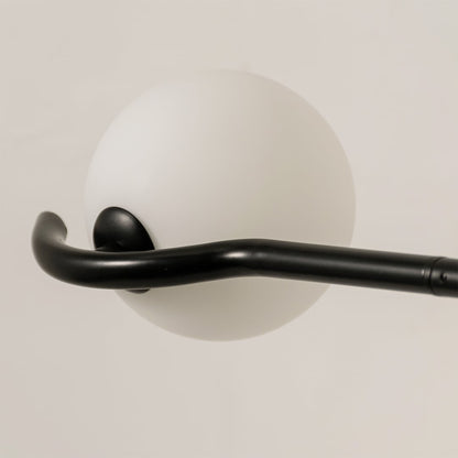 Detailed closeup of black chandelier highlighting sculpted arms and smooth white globes for contemporary home lighting decor.