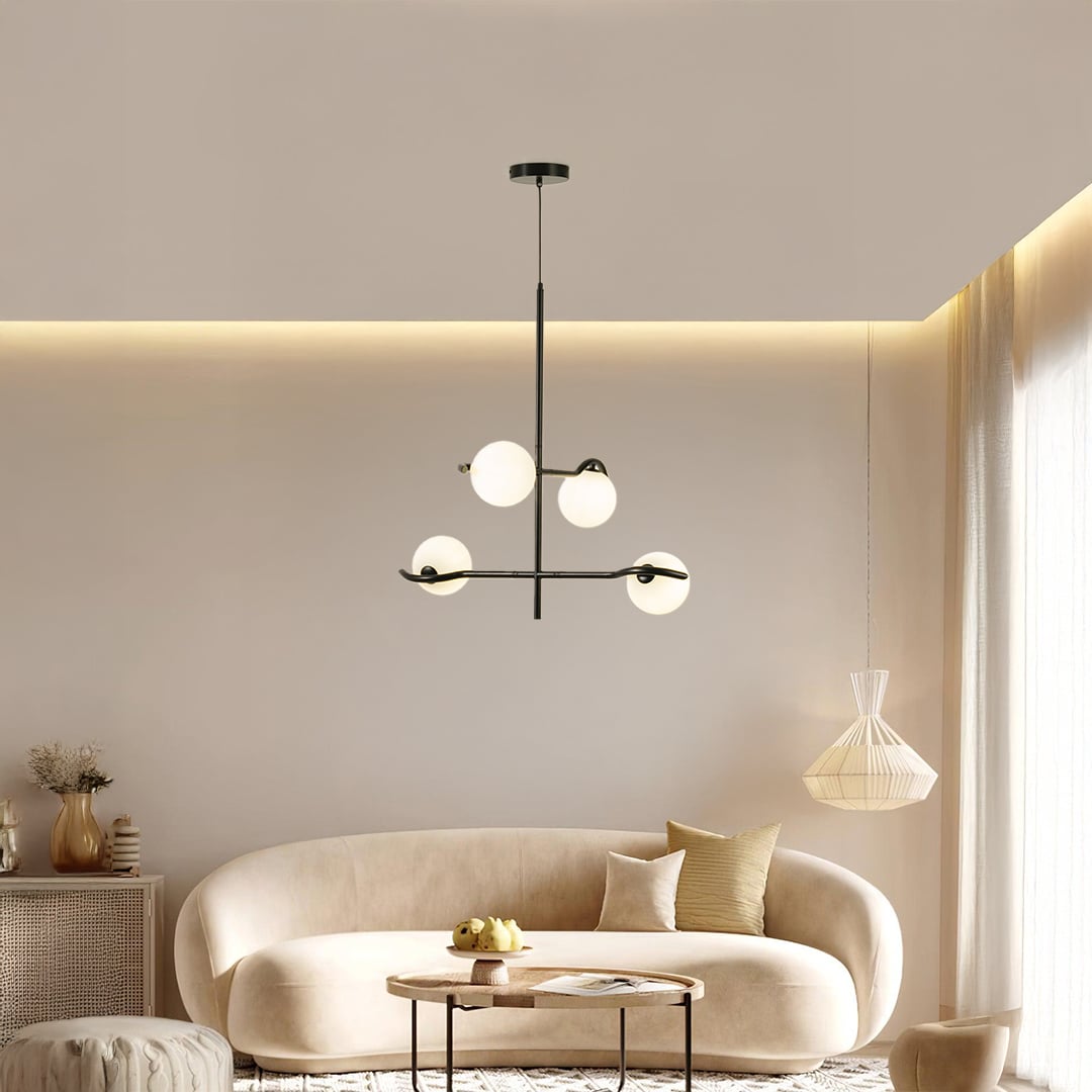 Black metal chandelier with white globes styled in a modern living room creating warm ambient lighting for elegant home decor.