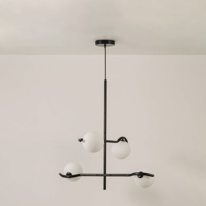 Black metal chandelier with white globes shown on a bright white background with lights off for a sleek minimal modern look.