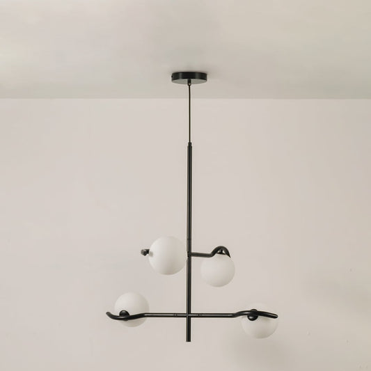 Black metal chandelier with white globes shown on a bright white background with lights off for a sleek minimal modern look.