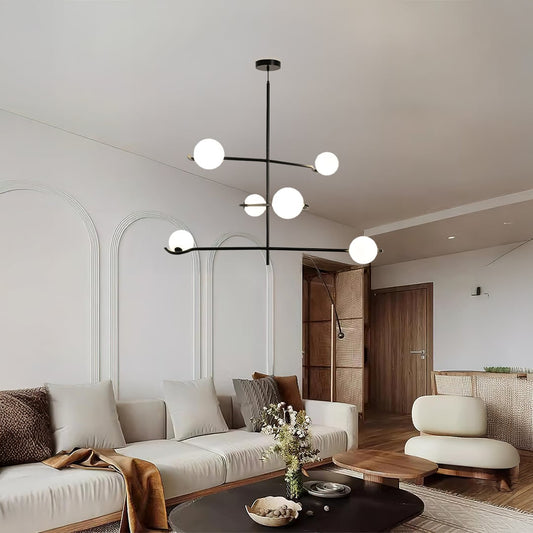 Black metal multi arm chandelier with white globes styled in a modern living space creating soft warm ambient ceiling lighting decor.