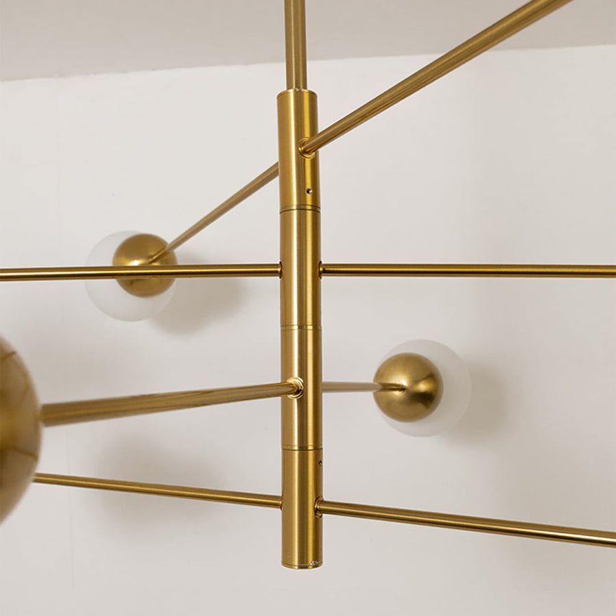 Closeup of modern gold metal chandelier arms and spherical mounts highlighting sleek lines premium finish and contemporary lighting craftsmanship.