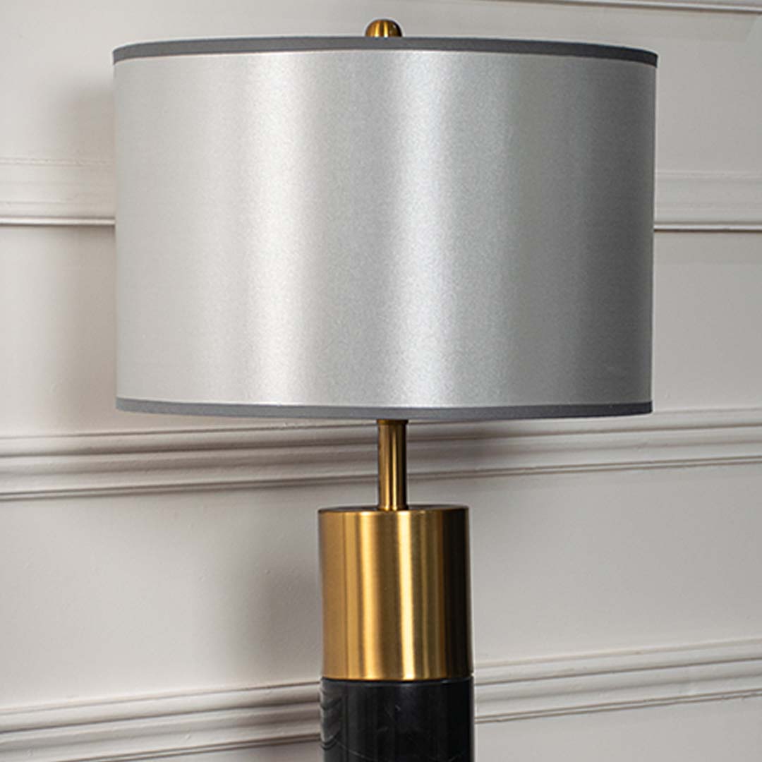 Grey shade gold base lamp on console table with light off and white wall panels for sleek modern décor.