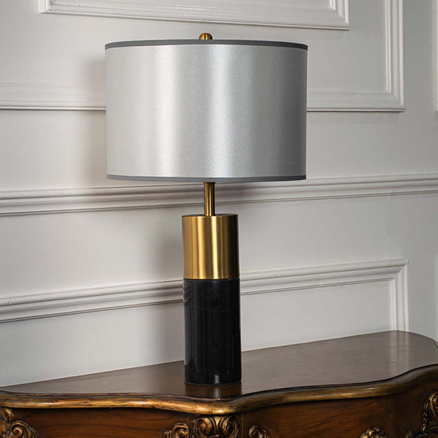 Silver shade gold and black table lamp on wooden console table with light off and white panel wall background for sleek modern décor.