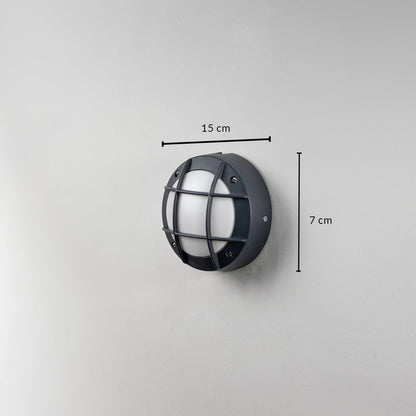 Round black outdoor wall light 15 cm wide and 7 cm deep displayed on white wall for lighting size reference.