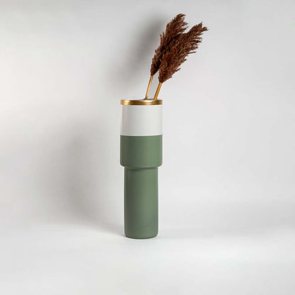Tall sage green ceramic vase with gold rim and white band placed in a bright interior perfect for modern living room and console styling.