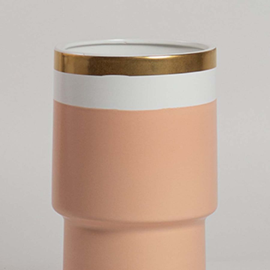 Closeup of peach ceramic vase showing its smooth finish white band and gold rim ideal for elegant contemporary home styling.
