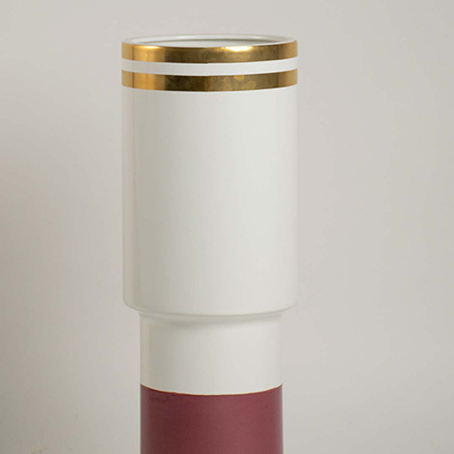 Closeup of white and maroon ceramic vase showing gold detailing and sleek modern design ideal for refined contemporary home accents.