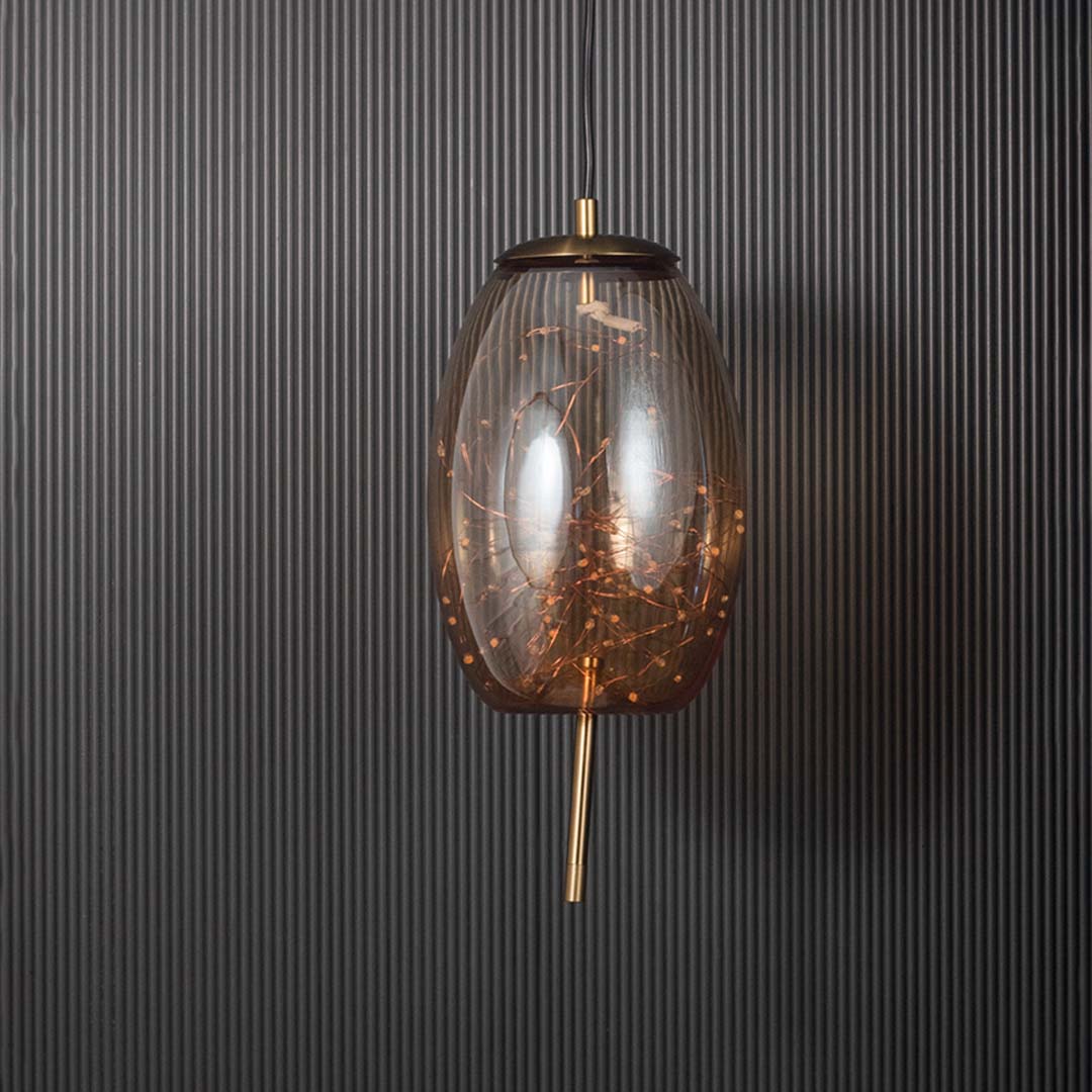 Amber glass and gold pendant ceiling light with intricate filament design displayed stylishly against black background.