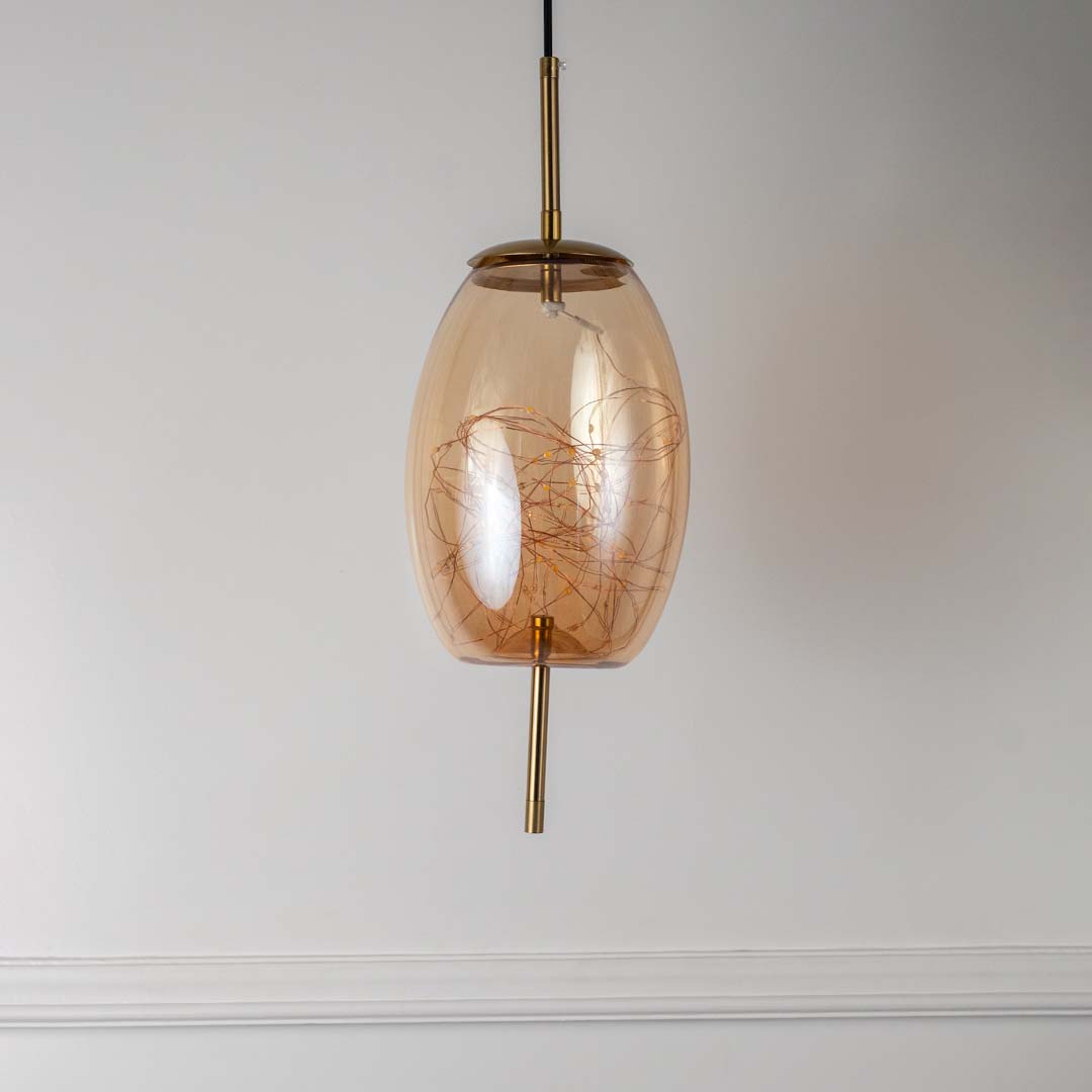 Amber glass and gold pendant ceiling light with artistic filament design displayed elegantly on off white background