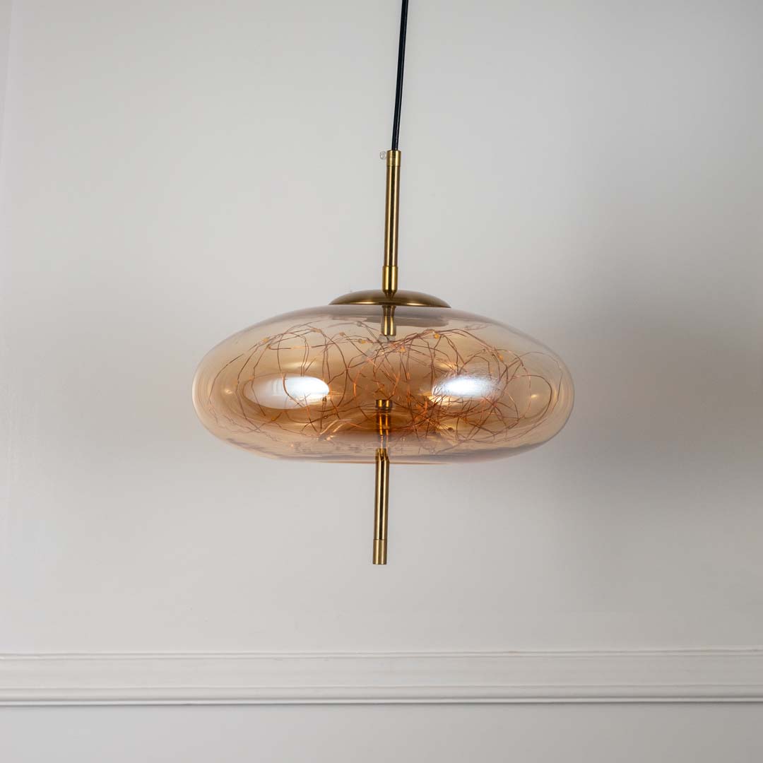 Flat amber glass pendant light with artistic wire detailing designed for stylish living spaces.