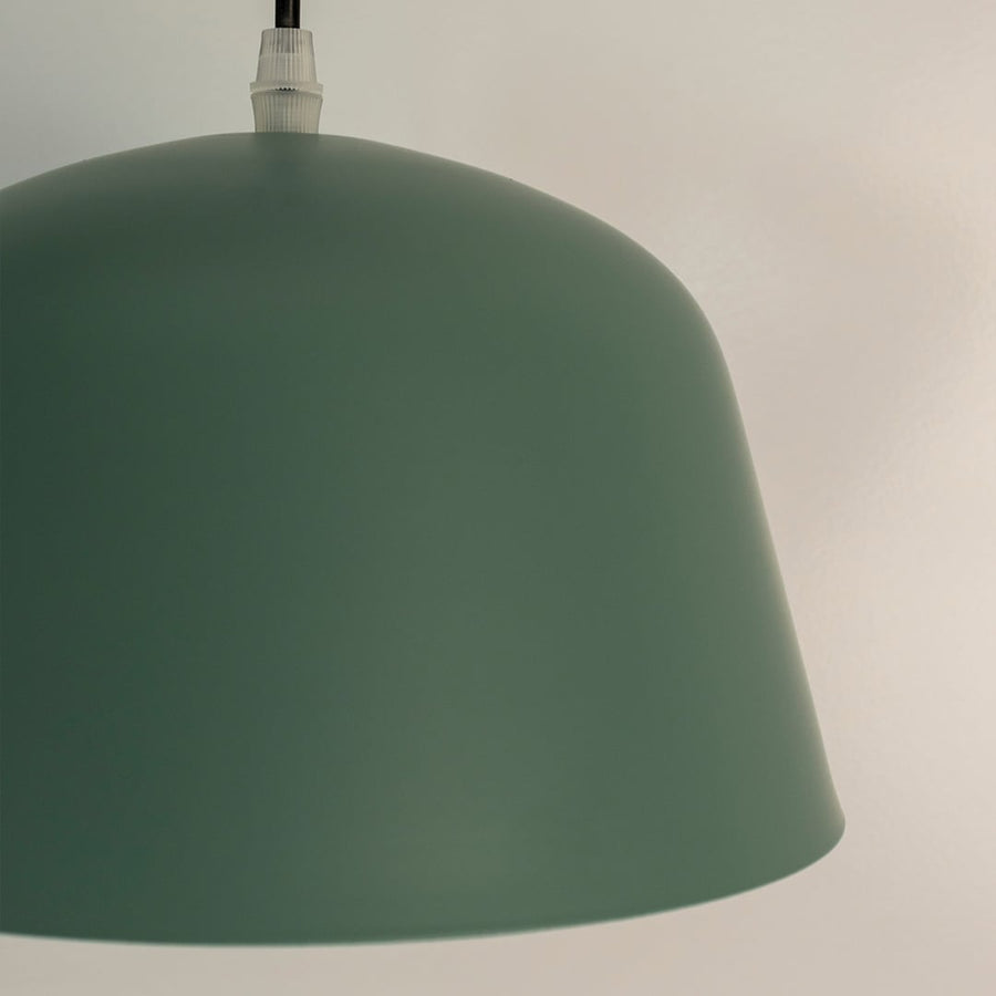 Closeup of matte green dome pendant light highlighting smooth finish and dome shaped design with elegant curve.