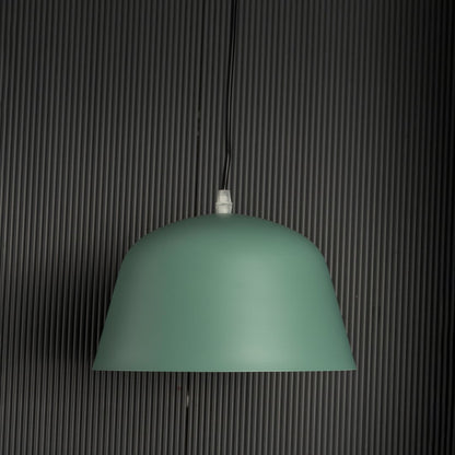 Matte green dome pendant light off black background featuring clean dome shape perfect for kitchens dining rooms or workspaces.