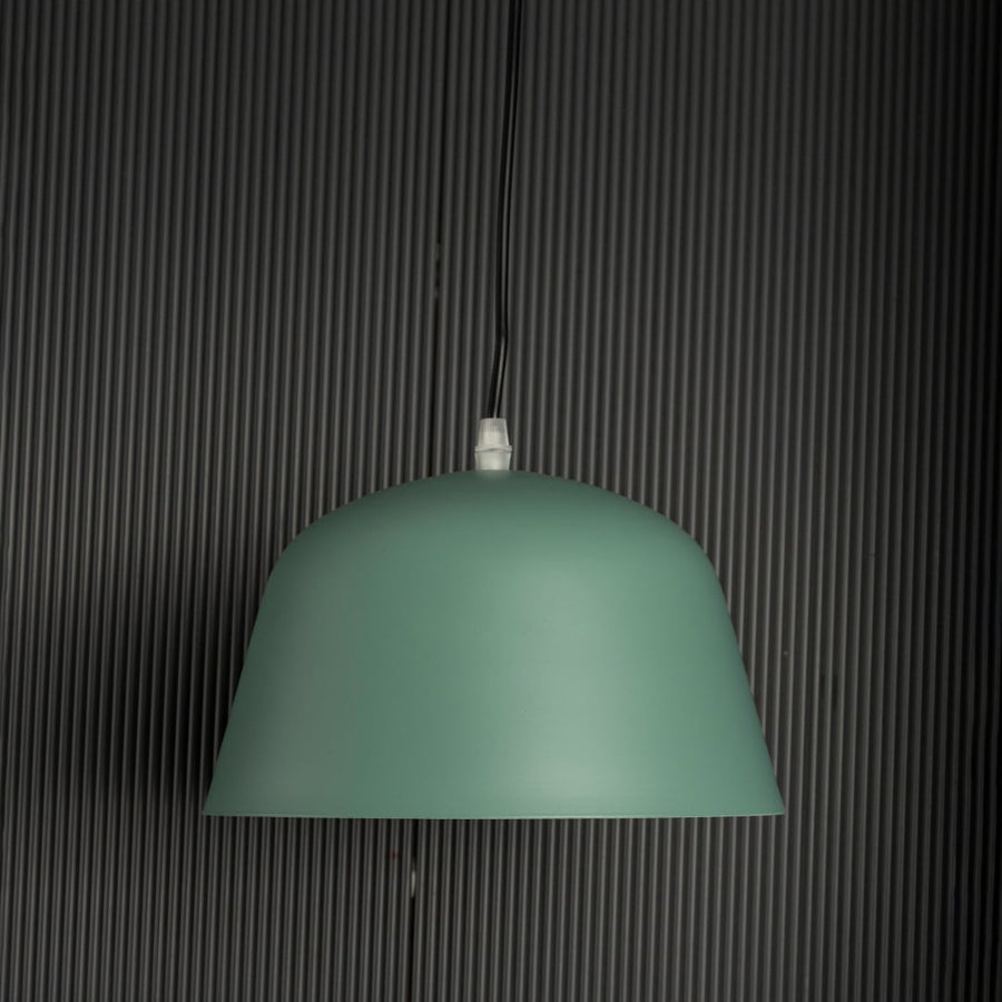 Matte green dome pendant light off black background featuring clean dome shape perfect for kitchens dining rooms or workspaces.