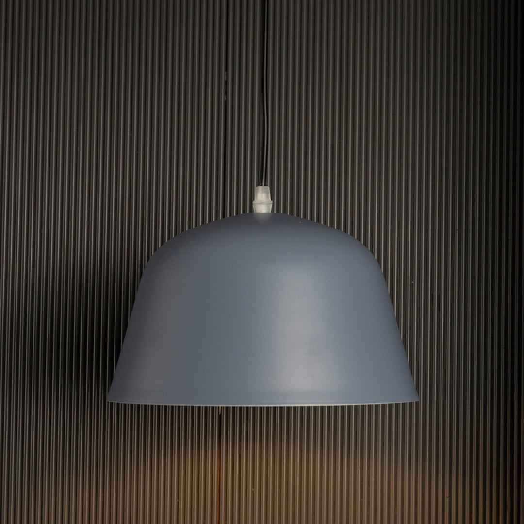 Matte blue dome pendant light on black background showcasing its sleek curved shade and soft matte finish.