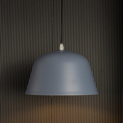 Matte blue dome pendant light on black background showcasing its sleek curved shade and soft matte finish.