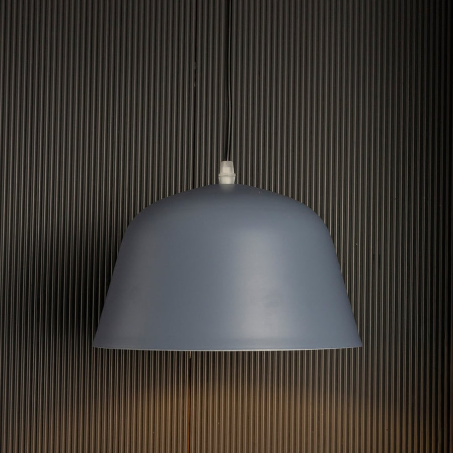 Matte blue dome pendant light on black background showcasing its sleek curved shade and soft matte finish.