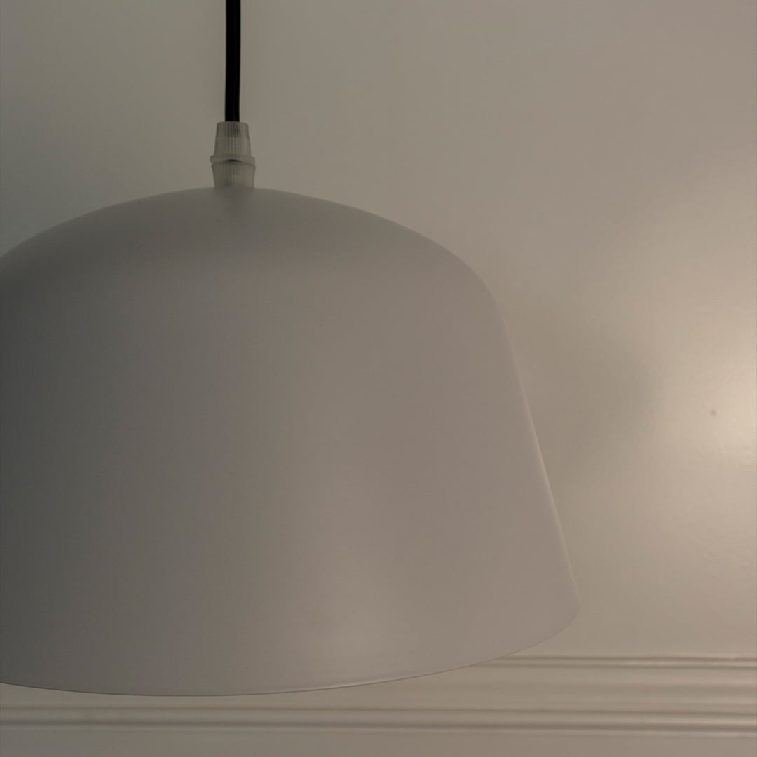 Macro shot of matte white dome pendant light focusing on its seamless smooth finish and elegant craftsmanship.