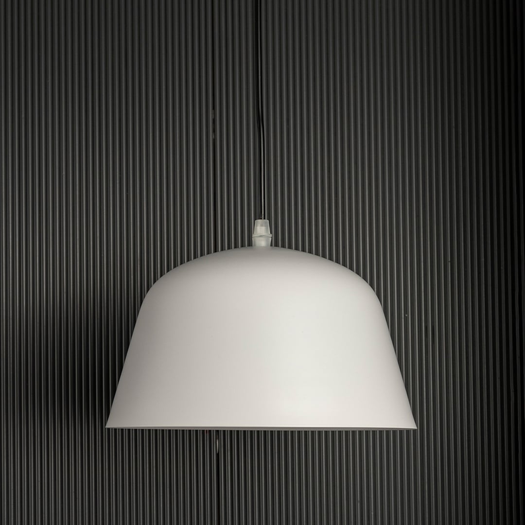 Matte white dome pendant light off gently against a dark background highlighting its smooth modern silhouette.