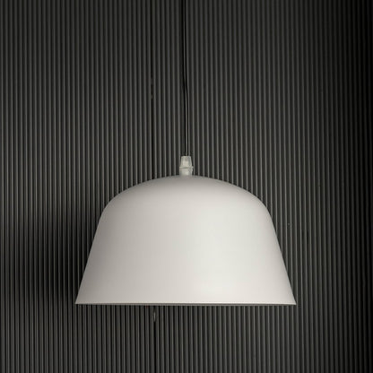 Matte white dome pendant light off gently against a dark background highlighting its smooth modern silhouette.