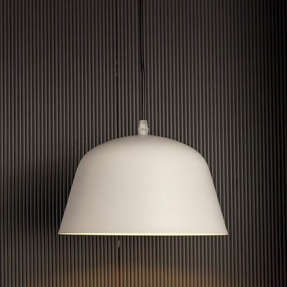 Matte white dome pendant lights softly glowing against black background together creating bright elegant lighting in modern interiors.