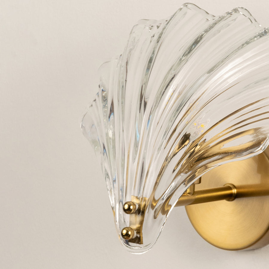 Elegant brass wall light with textured crystal glass shade for luxury modern interior wall decor.