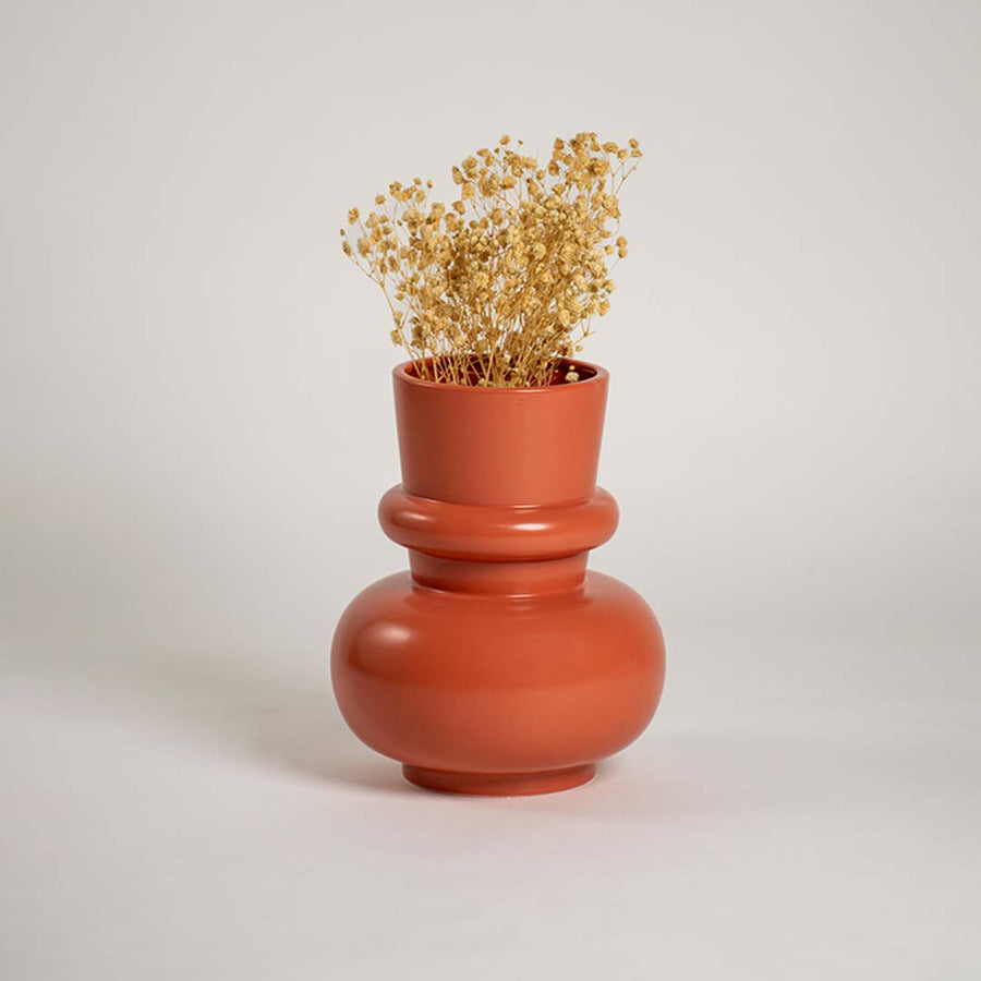 Terracotta orange modern decorative vase styled in a warm interior adding bold contemporary decor to consoles shelves and stylish living spaces.