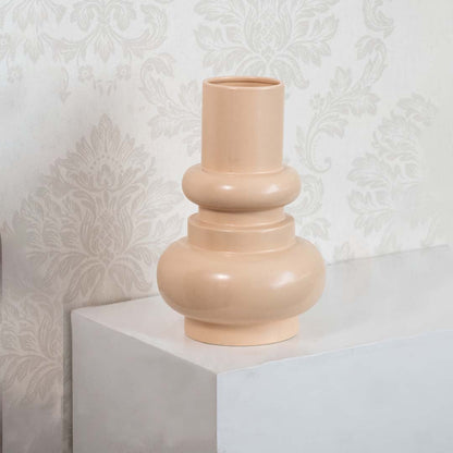 Peach sculptural ceramic vase displayed against a clean white background  highlighting its smooth curves and modern minimalist form.